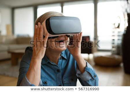 Foto d'archivio: Old Woman Wearing Virtual Reality Glasses At Home