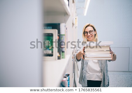 Foto d'archivio: Young Woman Carrying Pile Of Books