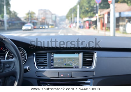 Foto stock: View From Inside A Car On A Part Of Dashboard With A Navigation Unit And Blurred Street In Front Of