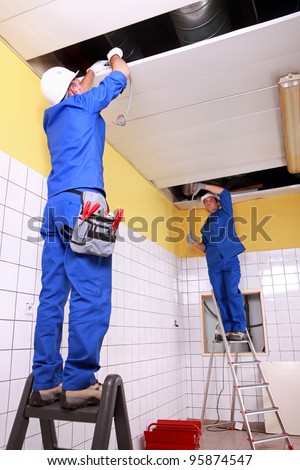 Stock photo: Electrician Wiring A Large Tiled Room