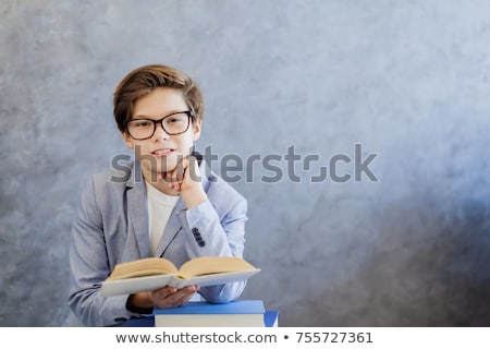 Foto stock: Cute Teenage Boy With Glasses Reading Book