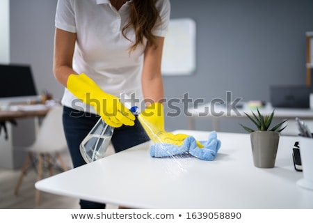 Stockfoto: Worker Cleaning Desk With Rag
