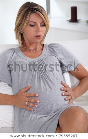 Foto stock: Woman Holding Her Very Pregnant Stomach