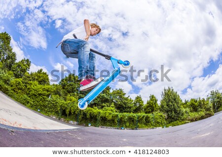 Stock photo: Boy Riding A Scooter Going Airborne