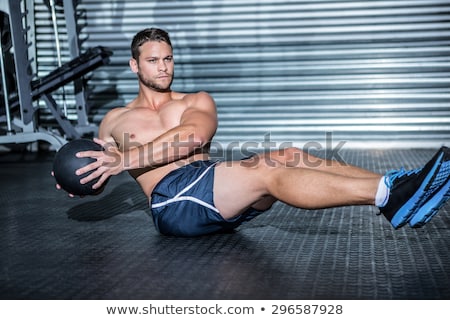 Foto d'archivio: Muscular Man Doing Exercise With Medicine Ball In Crossfit Gym
