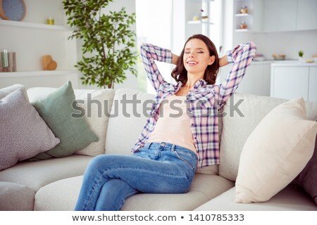 Foto stock: Girl Wearing Jeans Shorts Sitting On Sofa