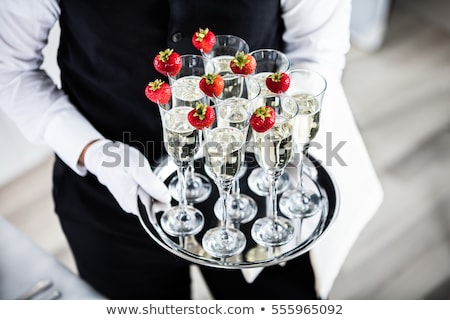 Stock fotó: Hand With Glove Holds Tray With Champagne Glasses