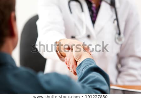 Stockfoto: Female Doctor Shaking Hands With Patient