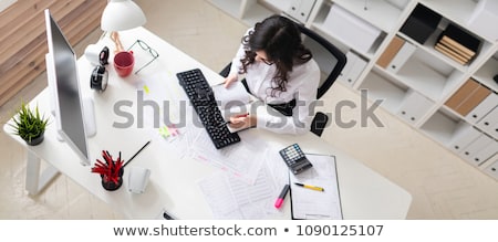 Stock fotó: Beautiful Young Girl In The Office Working With Documents Holding A Pen In Her Hand And Looking At