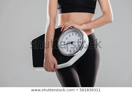 Stock photo: Woman Standing On Weighing Scale