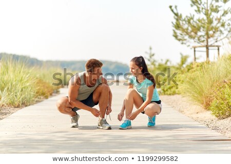 Zdjęcia stock: Couple Of Joggers Tying Sneakers Shoelaces