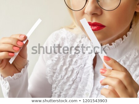 Foto stock: A Woman With Paper Strips In Her Hands Listens To The Fragrance