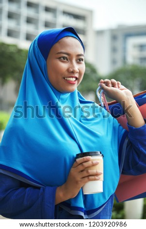 [[stock_photo]]: Cheerful Muslim Woman With Hot Drink And Paper Bags