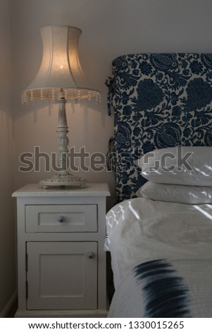 Zdjęcia stock: Front View Of An Illuminated Table Lamp Placed On A Cabinet Near The Bed In Bedroom At Home