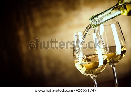 Foto d'archivio: Two Glasses Of White Wine Riesling And Bottle In Vineyard