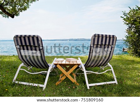 Stock fotó: Two Deck Chairs And Books At Lake