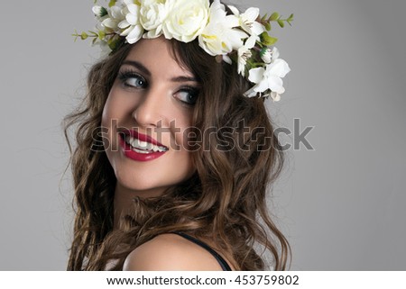 Foto d'archivio: Portrait Of A Smiling Cute Woman With Wreath Over Gray Background