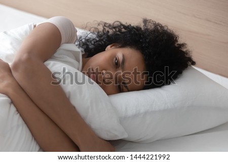 Foto stock: Tired Young African Woman Hugging A Pillow