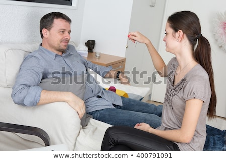 Foto stock: Woman Being Hypnotized With Pendulum Lying On Sofa