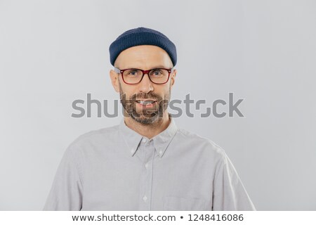 Stockfoto: Horizontal View Of Pleased Smiling Man Wears Glasses Hat And Shirt Being Satisfied With Good News