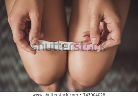 Stockfoto: Woman With A Pregnancy Test In A Toilet
