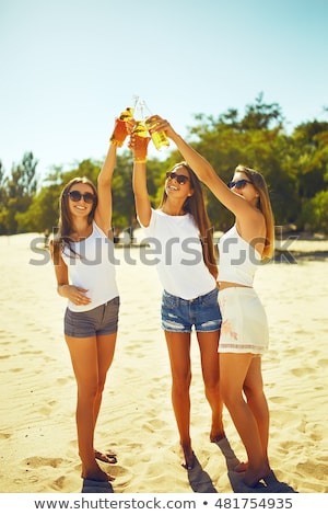 Сток-фото: Three Young Happy Girls In Bikini Drinking Outdoors
