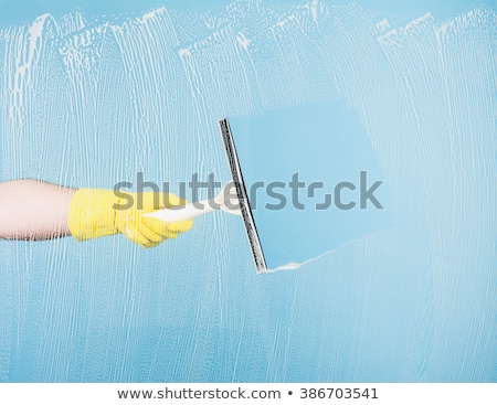 Foto stock: Hand Cleaning Glass Window Pane With Detergent And Wipe Or Sponge