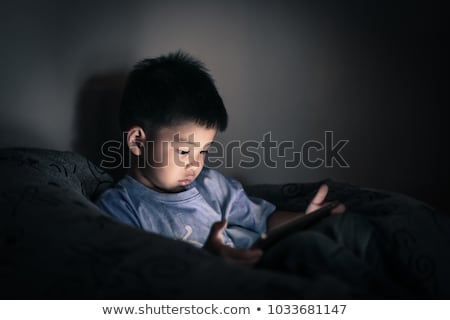 ストックフォト: Boy Watching Tablet In Darkness Living Room