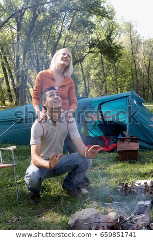 Сток-фото: Couple At Campsite Looking Up At Smoke