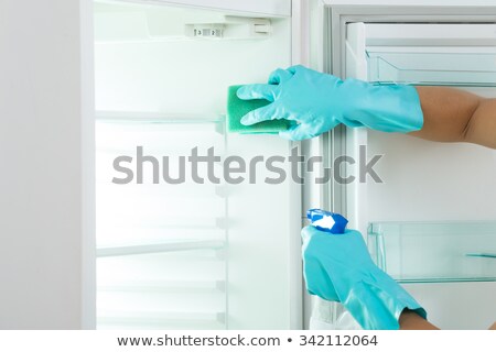 ストックフォト: Woman Cleaning Refrigerator With Sponge