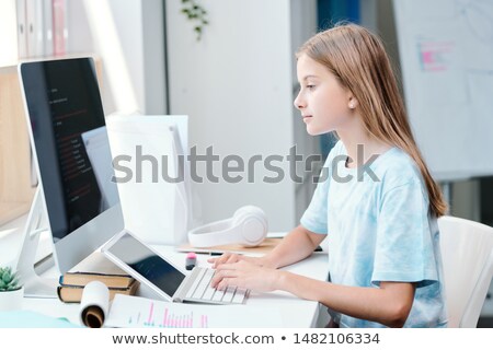 Zdjęcia stock: Serious Clever Schoolgirl Looking At Online Data On Computer Screen