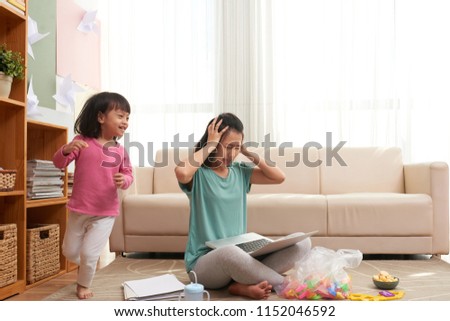 Foto stock: Stressed Woman Working At Home With Noisy Child