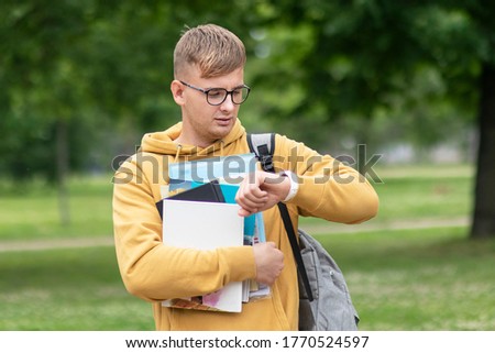 Foto d'archivio: Handsome Student Checking Time In Library