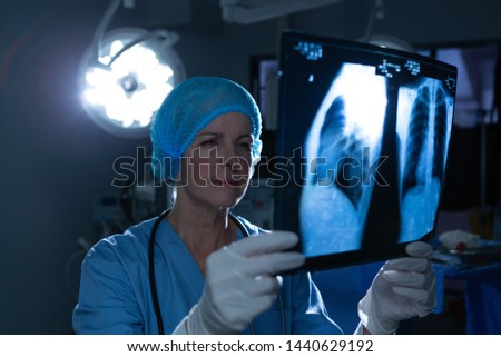 Сток-фото: Front View Of A Caucasian Female Surgeon Looking At A X Ray Picture In Operation Room In Hospital