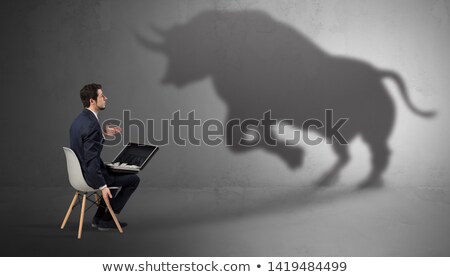 Stock foto: Businessman Staying And Offering Stuffs To A Huge Bull Shadow