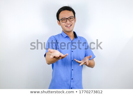 Foto stock: Smile And Happy Face Of Young Asian Man With Open Hand Gesture Advertising Model Concept With Blue