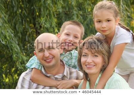 Zdjęcia stock: Cheerful Family With Two Children In Early Fall Park Son Is Embracing Father And Daughter Is Embrac