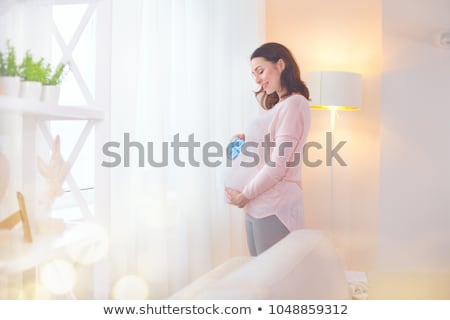 Stock fotó: Beautiful Happy Pregnant Woman Holding Little Baby Shoes