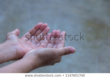 [[stock_photo]]: Girl Holding Her Hand Out To Catch Rain