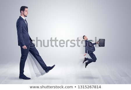 Foto stock: Big Man Kicking Little Himself Out