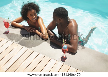 ストックフォト: High Angle View Of Young African American Couple Relaxing On Pool Lounger In A Swimming Pool In Thei