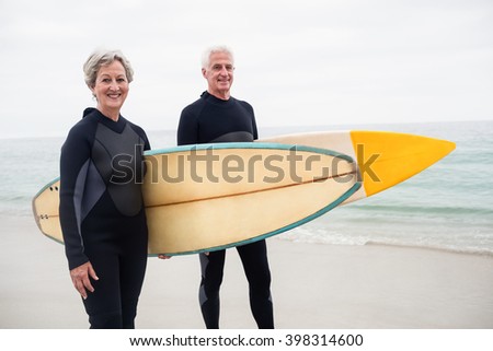 Zdjęcia stock: Front View Of Happy Senior Female Surfer With Surfboard Surfing In Sea On A Sunny Day