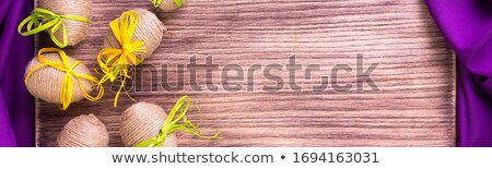 Stok fotoğraf: Banner Of Easter Egg In Twine Near Wooden And Purple Background