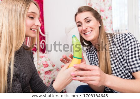 Stok fotoğraf: Mother Explaining Daughter How To Use A Condom