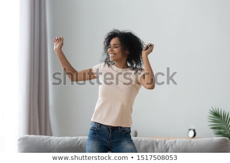 Zdjęcia stock: Young Woman Dancing With Mp3 Player In Hand