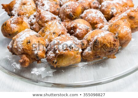 Stockfoto: Many Turnovers Or Oliebollen With Icing Sugar On Scale