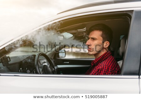 Foto stock: Side View Of Seated Man Smoking A Cigarette