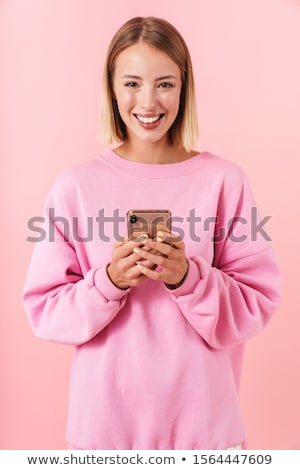 Foto stock: Portrait Of Optimistic Woman 20s Wearing Sweatshirt Using Mobile