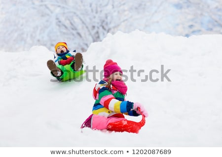 ストックフォト: Happy Kids Sliding On Sleds In Winter