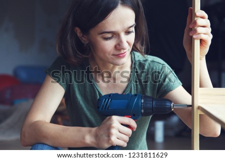 Stock photo: Tradesman Holding An Electric Screwdriver And A Wooden Plank